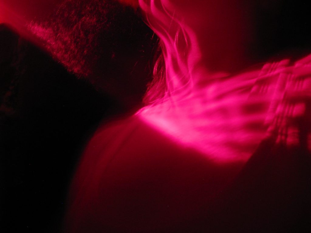 Red light in a dark club setting refraction on a collar bone
